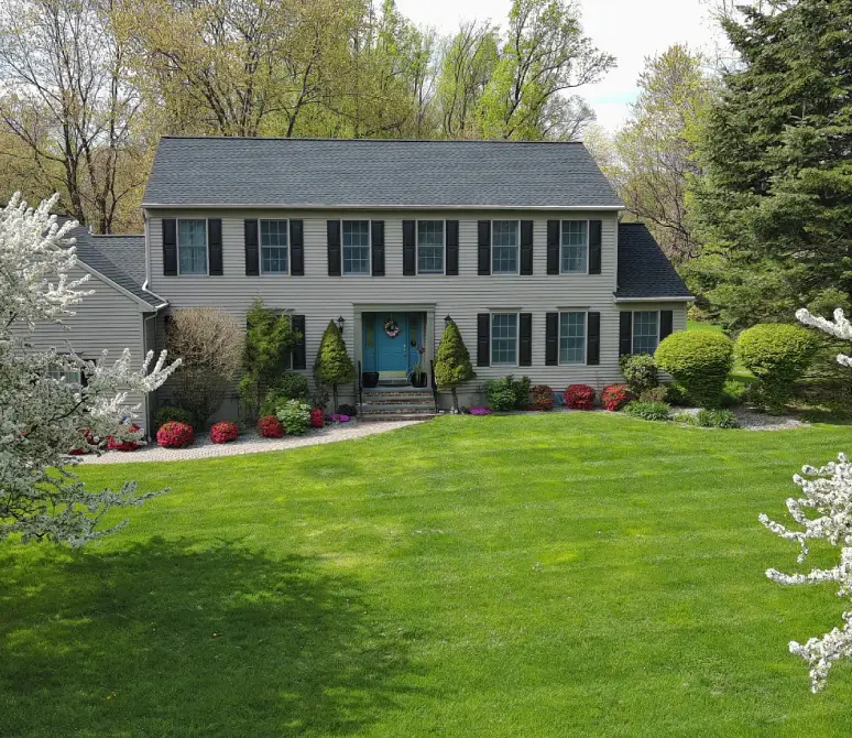 House with blue door and garden shrubs